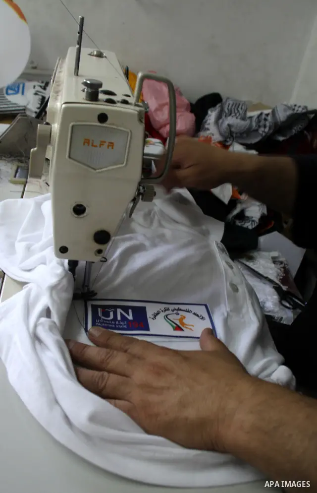 A Palestinian tailor sews United Nation logo on Shirts to be used in the national campaign to promote the Palestinian bid to obtain statehood recognition at the United Nations, at a factory in the West Bank city of Nablu...