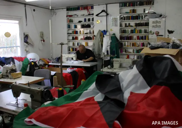 A Palestinian tailor sews national flags to be used in the national campaign to promote the Palestinian bid to obtain statehood recognition at the United Nations, at a factory in the West Bank city of Nablus on Sep. 13,...
