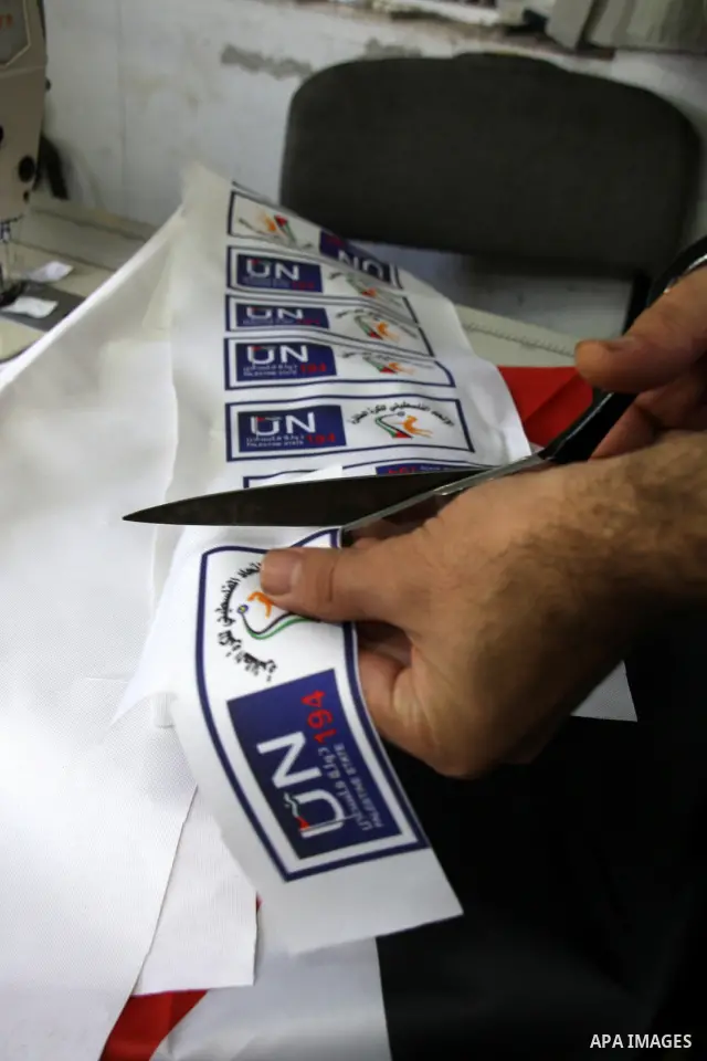 A Palestinian tailor sews United Nation logo to be used in the national campaign to promote the Palestinian bid to obtain statehood recognition at the United Nations, at a factory in the West Bank city of Nablus on Sep....