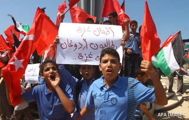 Palestinian students hold the pictures of Turkish Prime Minister Recep Tayyip Erdogan and the Turkish and Palestinian flags during rally beckoning him to visit the Gaza Strip at the port in Gaza City on Sep. 13, 2011. Er...