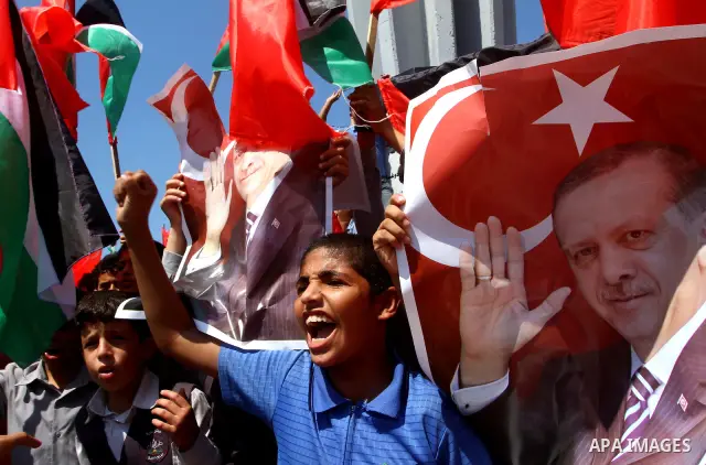 Palestinian students hold the pictures of Turkish Prime Minister Recep Tayyip Erdogan and the Turkish and Palestinian flags during rally beckoning him to visit the Gaza Strip at the port in Gaza City on Sep. 13, 2011. Er...