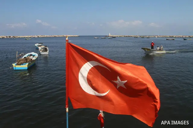 Turkish flag while the Palestinian students hold pictures of Turkish Prime Minister Recep Tayyip Erdogan and the Turkish and Palestinian flags during rally beckoning him to visit the Gaza Strip at the port in Gaza City o...