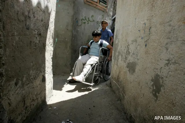 A Palestinian boy sits on a chair disabled in front of his home at the street in the Rafah Refugee Camp, Southern Gaza Strip on September 13, 2011. A diplomatic showdown looms at the United Nations this month when Palest...