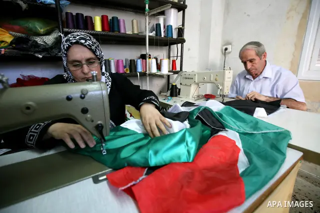 Palestinian Nabil al-Saed and his wife Nabila make Palestinian flags in a factory in the West Bank city of Hebron on 13 September 2011. According to Nabil al-Saed, with the Palestinian push for recognition of statehood a...