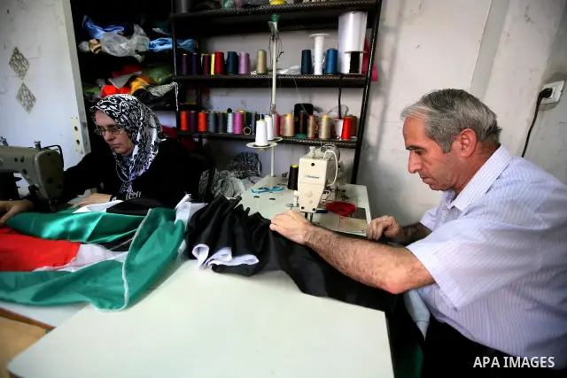Palestinian Nabil al-Saed and his wife Nabila make Palestinian flags in a factory in the West Bank city of Hebron on 13 September 2011. According to Nabil al-Saed, with the Palestinian push for recognition of statehood a...