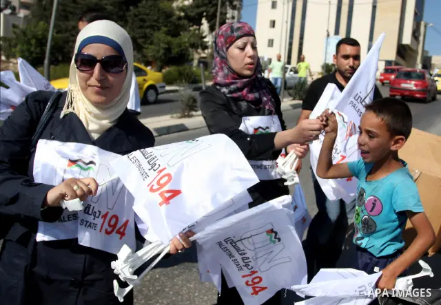 Activists of the Palestine 194 campaign distribute flags and leaflets to motorists in order to drum for Palestine to become the 194th state recognised by the UN, in the West bank town of Ramallah, on 13 September 2011. T...