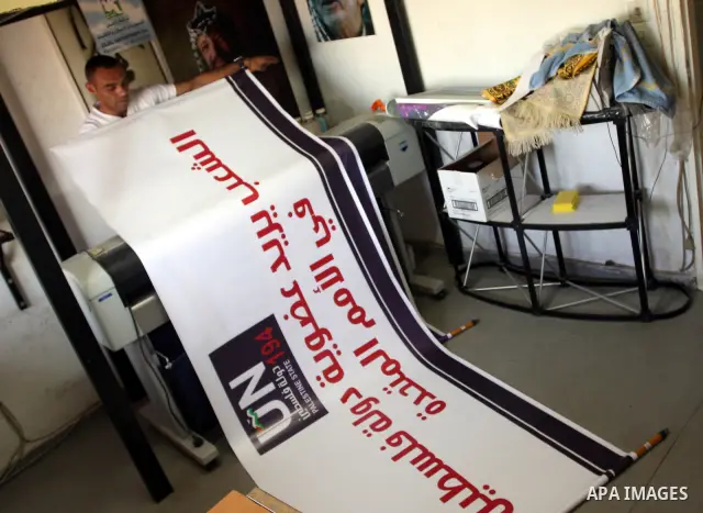 A Palestinian worker inspects a banner as it prints in the West Bank city of Ramallah September 13, 2011. A grass-root campaign supporting the upcoming Palestinian bid at the United Nations is gearing up for the diplomat...