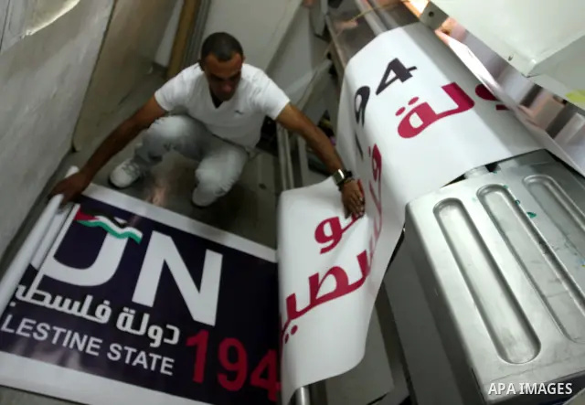 A Palestinian worker inspects a banner as it prints in the West Bank city of Ramallah September 13, 2011. A grass-root campaign supporting the upcoming Palestinian bid at the United Nations is gearing up for the diplomat...