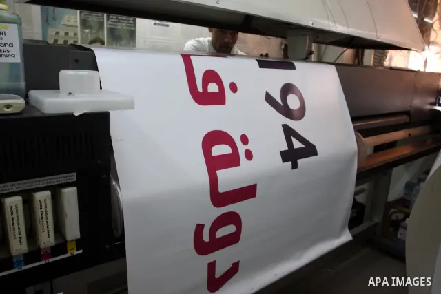 A Palestinian worker inspects a banner as it prints in the West Bank city of Ramallah September 13, 2011. A grass-root campaign supporting the upcoming Palestinian bid at the United Nations is gearing up for the diplomat...