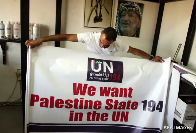 A Palestinian worker inspects a banner as it prints in the West Bank city of Ramallah September 13, 2011. A grass-root campaign supporting the upcoming Palestinian bid at the United Nations is gearing up for the diplomat...