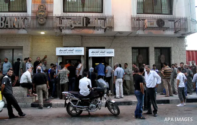 Palestinian Authority civil servants gather outside the Arab Bank in Gaza city on Sep. 13,2011, to withdraw their monthly salaries which were delayed for ten days from the begining of the new month. Photo by Mohammed Asa...