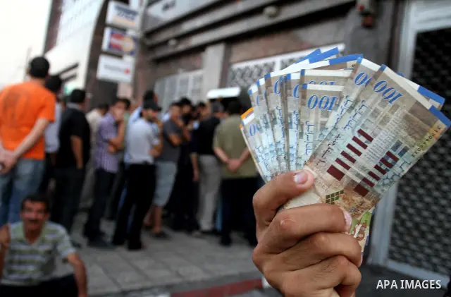 Palestinian Authority civil servants gather outside the Arab Bank in Gaza city on Sep. 13,2011, to withdraw their monthly salaries which were delayed for ten days from the begining of the new month. Photo by Mohammed Asa...
