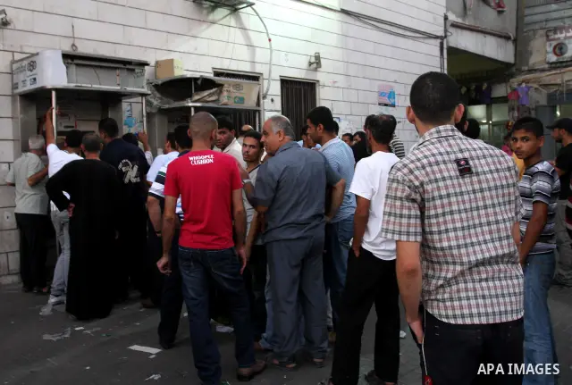 Palestinian Authority civil servants gather outside the Arab Bank in Gaza city on Sep. 13,2011, to withdraw their monthly salaries which were delayed for ten days from the begining of the new month. Photo by Mohammed Asa...