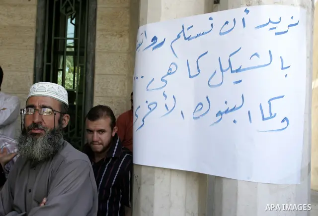 Employees of the Palestinian Authority reject to receive their salaries from the Islamic Bank in Rafah, southern Gaza Strip on Sep. 14, 2011. They explained that this procedure is deducted from the salary of each employe...