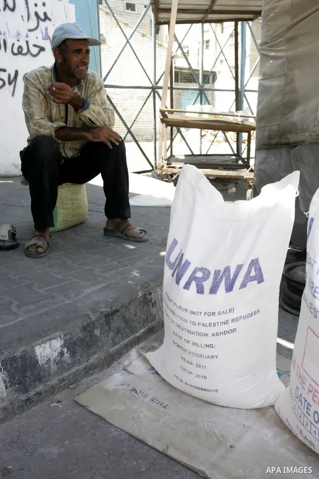 A Palestinian man sits near food aid receiving from a UN distribution centre in the Rafah refugee camp, southern Gaza Strip on Sep. 14, 2011. Germany provided for the first time a donation to the school's nutrition progr...