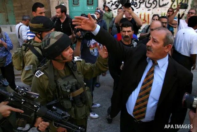 A Palestinian man argues with Israeli soldiers during a rally against the closure of Shuhada Street in Hebron, the main artery blocked by an Israeli military checkpoint in the center of the West Bank town of Hebron Sep....