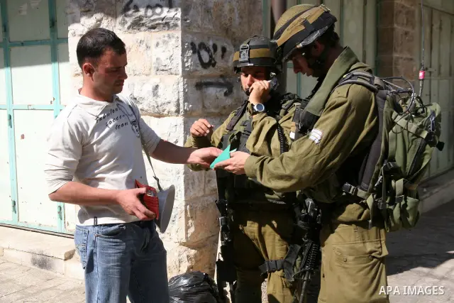 A Palestinian man argues with Israeli soldiers during a rally against the closure of Shuhada Street in Hebron, the main artery blocked by an Israeli military checkpoint in the center of the West Bank town of Hebron Sep....