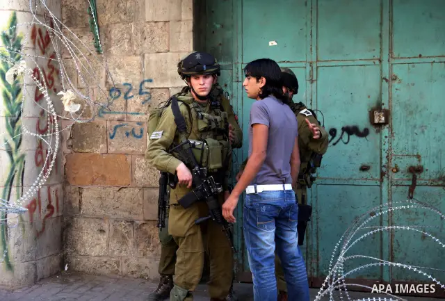 A Palestinian man argues with Israeli soldiers during a rally against the closure of Shuhada Street in Hebron, the main artery blocked by an Israeli military checkpoint in the center of the West Bank town of Hebron Sep....