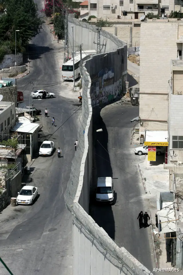 Palestinians walk past a section of Israel's controversial concrete barrier that separates the West Bank from Jerusalem on September 14, 2011. in Abu Dis, in Israeli-annexed east Jerusalem. Photo by Mahfouz Abu Turk