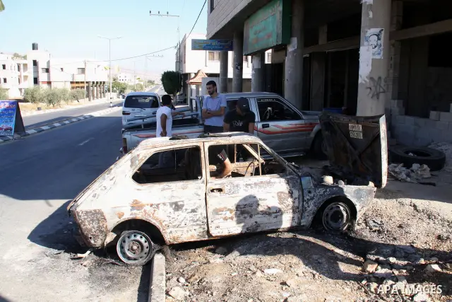 Palestinians inspect a burnt car in the village of Beit Furik, near the West Bank town of Nablus, on Sept. 15, 2011. Vandals set fire to three cars in a West Bank village, and suspicion has fallen on Jewish settlers. Pal...