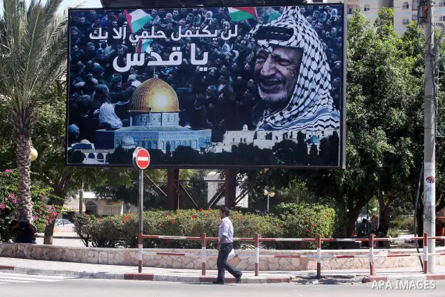 A Palestinian man walks near a big banner for the late Palestinian leader Yasser Arafat in Gaza City, on Sep. 15, 2011 as the Palestinians prepare to submit a formal request to become the 194th member of the United Natio...