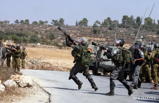 Israeli soldiers shoot tear gas canisters toward Palestinian demonstrators during a protest against the expansion of the nearby Jewish settlement of Halamish, in the West Bank village of Nabi Saleh, near Ramallah, Friday...