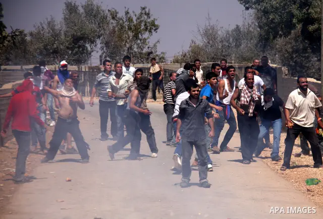 Palestinians hurl rocks at Israeli soldiers during clashes at Qusra village near the West Bank city of Nablus on 16 September 2011. Israeli settlers assaulted the village Friday morning, leading to clashes with Israeli f...