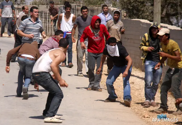 Palestinians hurl rocks at Israeli soldiers during clashes at Qusra village near the West Bank city of Nablus on 16 September 2011. Israeli settlers assaulted the village Friday morning, leading to clashes with Israeli f...