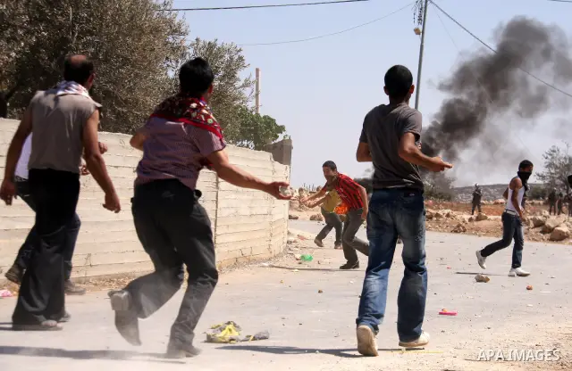 Palestinians hurl rocks at Israeli soldiers during clashes at Qusra village near the West Bank city of Nablus on 16 September 2011. Israeli settlers assaulted the village Friday morning, leading to clashes with Israeli f...