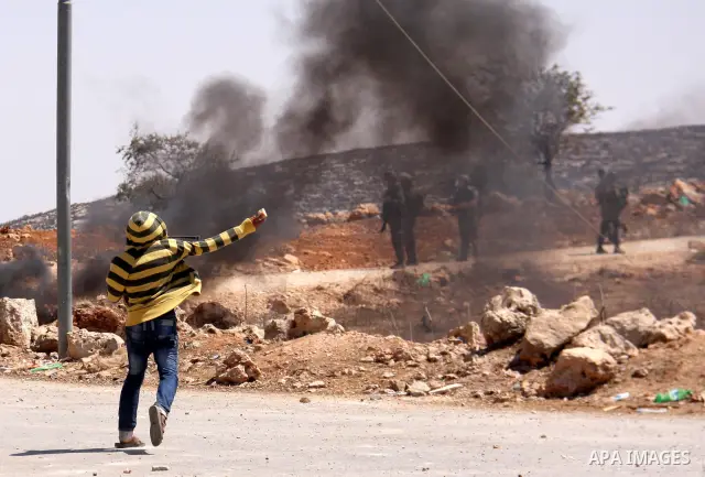 Palestinians hurl rocks at Israeli soldiers during clashes at Qusra village near the West Bank city of Nablus on 16 September 2011. Israeli settlers assaulted the village Friday morning, leading to clashes with Israeli f...