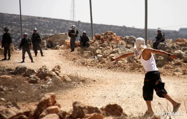 Palestinians hurl rocks at Israeli soldiers during clashes at Qusra village near the West Bank city of Nablus on 16 September 2011. Israeli settlers assaulted the village Friday morning, leading to clashes with Israeli f...