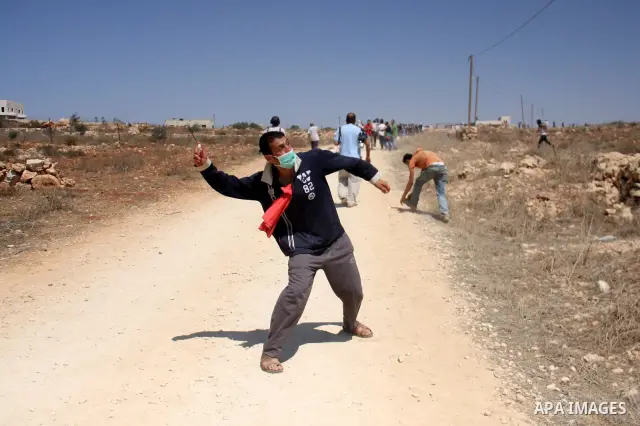 Palestinians hurl rocks at Israeli soldiers during clashes at Qusra village near the West Bank city of Nablus on 16 September 2011. Israeli settlers assaulted the village Friday morning, leading to clashes with Israeli f...