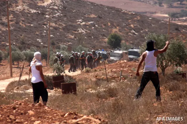 Palestinians hurl rocks at Israeli soldiers during clashes at Qusra village near the West Bank city of Nablus on 16 September 2011. Israeli settlers assaulted the village Friday morning, leading to clashes with Israeli f...