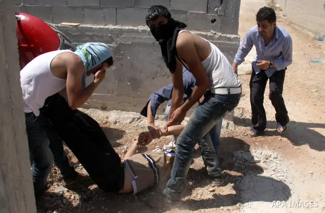 Palestinians help a man who was hit by a rubber bullet during clashes with Israeli troops at Qusra village near the West Bank city of Nablus on 16 September 2011. Israeli settlers assaulted the village Friday morning, le...