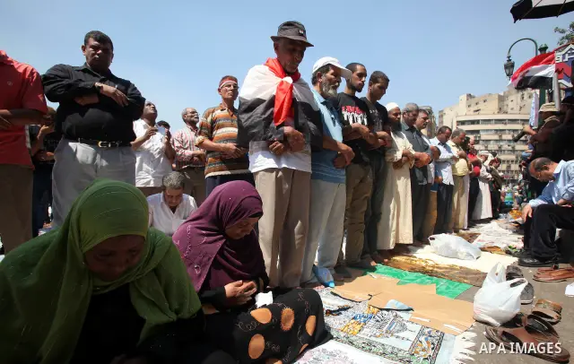 Egyptians during performing their Friday prayers while hundreds of Egyptians demonstrate against the expansion of the Emergency Law at Al Tahrir Square. The law allows censorship, government imprisonment and more during...