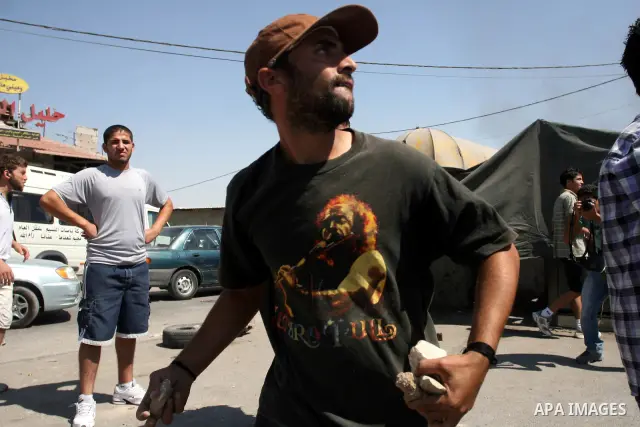 Palestinian youths throw stones at Israeli forces during a protest calling for a Palestinian state with full UN membership at the Qalandia Israeli checkpoint in the West Bank, near Ramallah, on Sep. 17, 2011. The Palesti...