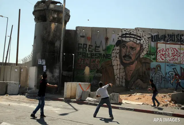 Palestinian youths throw stones at Israeli forces during a protest calling for a Palestinian state with full UN membership at the Qalandia Israeli checkpoint in the West Bank, near Ramallah, on Sep. 17, 2011. The Palesti...
