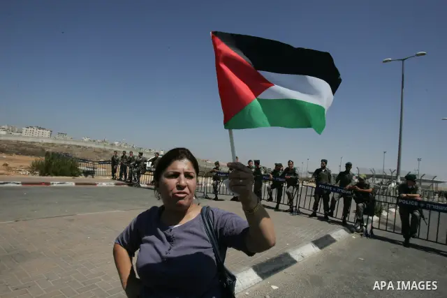 Palestinian women, joined by foreign peace activists and left-wing Israelis, hold up placards calling for a Palestinian state with full UN membership during a protest in Jerusalem, on 17 September 2011. Palestine is set...