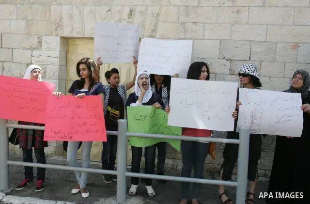 Palestinian women, joined by foreign peace activists and left-wing Israelis, hold up placards calling for a Palestinian state with full UN membership during a protest in Jerusalem, on 17 September 2011. Palestine is set...