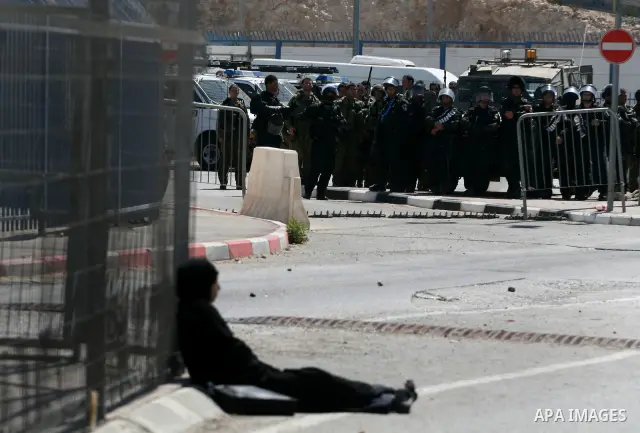 A Palestinian woman who identified herself as Neda, from the West Bank city of Bethlehem, sit in defiance within the crossing point of Qalandia at the entrance of Jerusalem on September 17, 2011, in a zone otherwise stri...