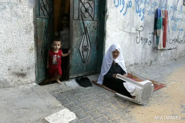 A Palestinian woman sits outside her house with her child at Rafah refugee camp, southern Gaza Strip on Sep. 17, 2011. The Palestinians are preparing to submit a formal request to become the 194th member of the United Na...