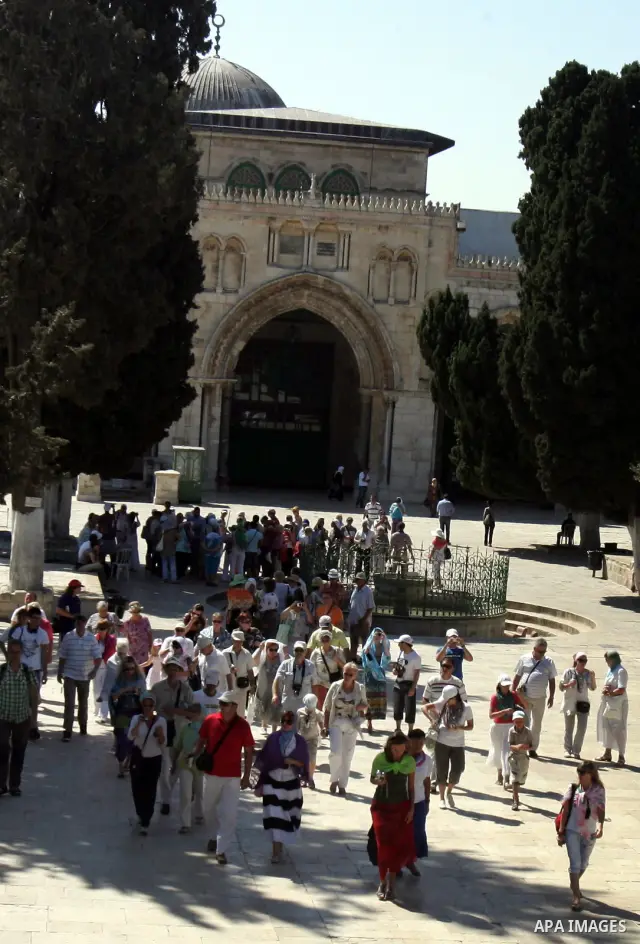 A group of religious Jews walks in front of the Dome of the Rock on a visit to the Al-Aqsa mosques compound under Israeli police protection in Jerusalem's Old City on September 18, 2011. The Dome of the Rock (C), Islam's...