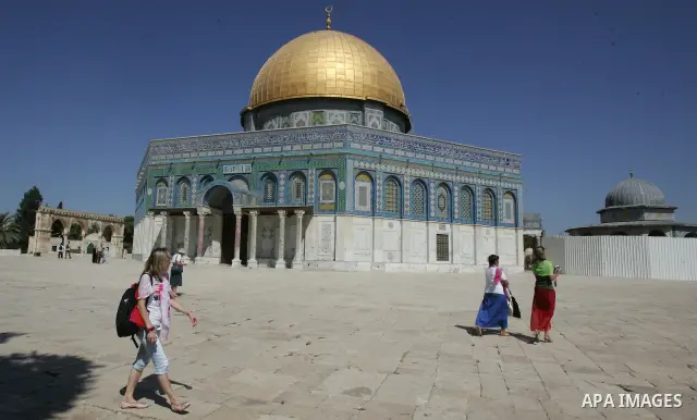 A group of religious Jews walks in front of the Dome of the Rock on a visit to the Al-Aqsa mosques compound under Israeli police protection in Jerusalem's Old City on September 18, 2011. The Dome of the Rock (C), Islam's...
