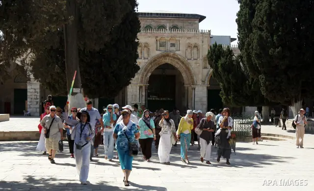 A group of religious Jews walks in front of the Dome of the Rock on a visit to the Al-Aqsa mosques compound under Israeli police protection in Jerusalem's Old City on September 18, 2011. The Dome of the Rock (C), Islam's...