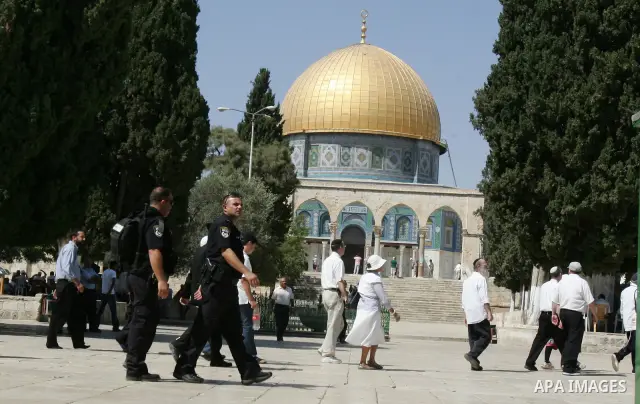 A group of religious Jews walks in front of the Dome of the Rock on a visit to the Al-Aqsa mosques compound under Israeli police protection in Jerusalem's Old City on September 18, 2011. The Dome of the Rock (C), Islam's...