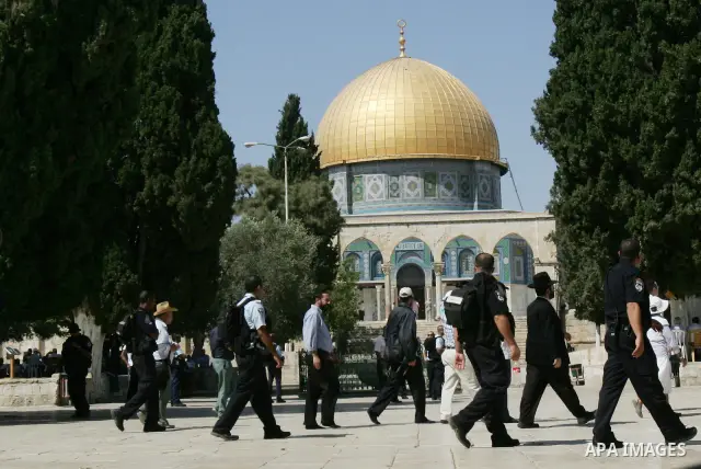 A group of religious Jews walks in front of the Dome of the Rock on a visit to the Al-Aqsa mosques compound under Israeli police protection in Jerusalem's Old City on September 18, 2011. The Dome of the Rock (C), Islam's...