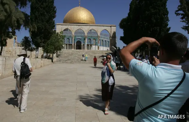 A Jewish man takes pictures of the Dome of the Rock (C) during a visit by a group of religious Jews to the Al-Aqsa mosques compound under Israeli police protection in Jerusalem's Old City on September 18, 2011. Al-Aqsa c...