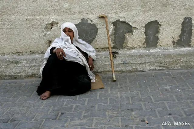 A Palestinian woman sits on a street on September 18, 2011, at refugee camp in the southern Gaza Strip. The Palestinians are preparing to submit a formal request to become the 194th member of the United Nations when the...
