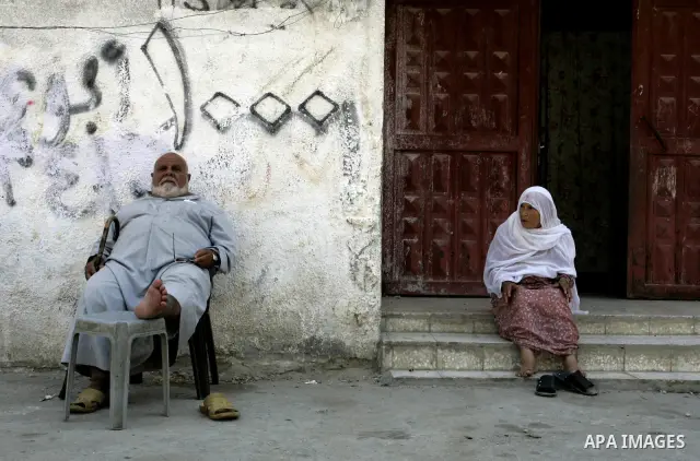 Palestinian man and woman sit on a street on September 18, 2011, at refugee camp in the southern Gaza Strip. The Palestinians are preparing to submit a formal request to become the 194th member of the United Nations when...