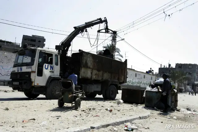 A Palestinian man stands past a UN truck collecting garbage on September 18, 2011, at refugee camp in the southern Gaza Strip. The Palestinians are preparing to submit a formal request to become the 194th member of the U...